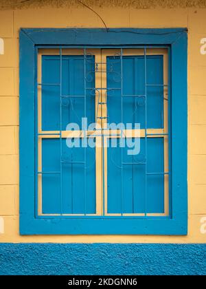 Finestra blu su sfondo giallo, caratteristica della città di Jerico, Antioquia, Colombia Foto Stock