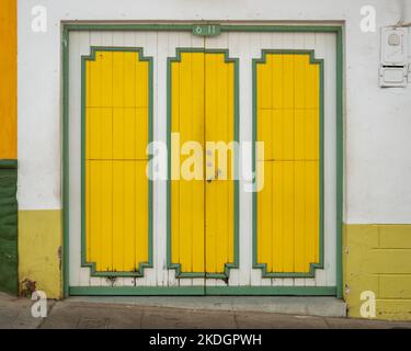 Porta verde e gialla su sfondo bianco, caratteristica della città di Jerico, Antioquia, Colombia Foto Stock