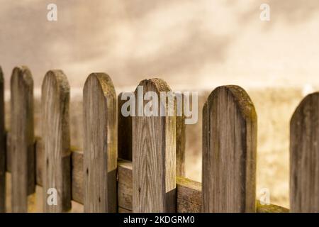 Recinzione in legno con ombra sul muro di cemento Foto Stock
