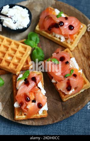 Sandwich al salmone con cialde viennesi e ricotta. Deliziosi waffle con salmone e formaggio cremoso. Foto Stock