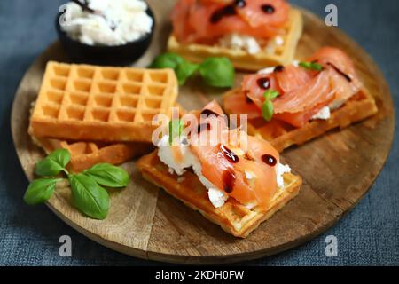 Sandwich al salmone con cialde viennesi e ricotta. Deliziosi waffle con salmone e formaggio cremoso. Foto Stock