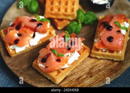 Sandwich al salmone con cialde viennesi e ricotta. Deliziosi waffle con salmone e formaggio cremoso. Foto Stock