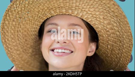 Primo piano ritratto di una giovane donna caucasica sorridente che indossa un cappello di paglia Foto Stock