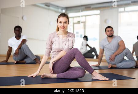 Donna seduta nel signore dei pesci posa, formazione di gruppo Foto Stock