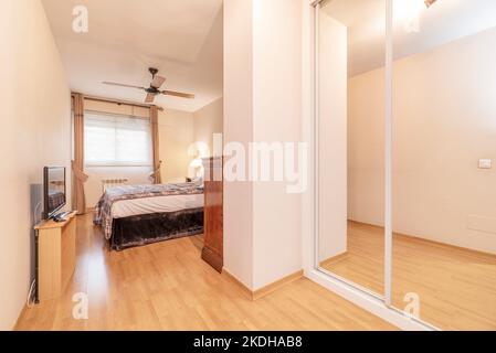 Elegante camera con letto matrimoniale, armadio a specchio e tv Foto stock  - Alamy