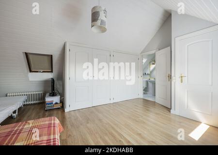Camera matrimoniale con bagno interno e spogliatoio al piano attico di una casa singola Foto Stock