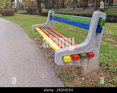 Panca in legno colorata e creativa di Street Park dipinta in colori luminosi Foto Stock