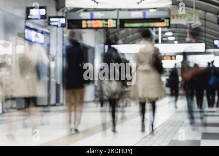 Il business aziendale persone pendolari da Tokyo il trasporto pubblico. Irriconoscibile blured persone in movimento mentre si precipitano a binari del treno. Foto Stock