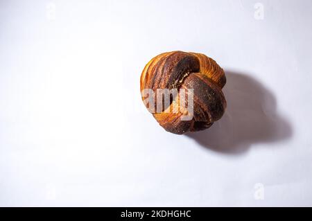 Gnocchi di rotolo di cannella o di panino del mattino tipicamente fatti per il consumo a colazione ma serve in ogni occasione, sfondo bianco per il taglio. Foto Stock