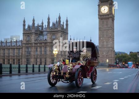 Londra, Regno Unito. 6th novembre 2022. L'emittente Alan Titchmarsh (a destra) si unisce a Londra alla Brighton Veteran Car Run. Nonostante le forti precipitazioni, oltre 350 vetture veterane, prodotte prima del 1905 con i loro piloti e passeggeri - molti in costume d'epoca, passano attraverso Westminster sulla strada per Brighton. La corsa in auto è l'evento motoristica più lungo al mondo, con la prima risalente al novembre 1896. Credit: Guy Corbishley/Alamy Live News Foto Stock