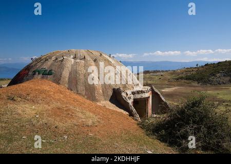 Uno dei 750.000 bunker in acciaio e cemento costruiti in tutta l'Albania durante l'era comunista, questo si trova vicino alla città di Tirana, Albania. Foto Stock