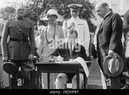 Il Presidente Coolidge firmando le fatture di appropriazione per il Veterans Bureau sul South Lawn durante la festa in giardino per i veterani feriti, 5 giugno 1924. Il generale John J. Pershing è sulla sinistra. L'uomo a destra, guardando sopra, sembra essere il direttore del Veterans Bureau Frank T. Hines. Foto Stock