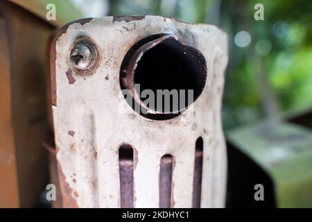 Primo piano del tubo di scarico di un trattore retrostante su uno sfondo sfocato Foto Stock