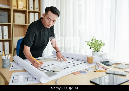 Designer d'interni creativi che lavorano su un grande progetto per il cliente, controllando il progetto e raccogliendo campioni di materiali Foto Stock