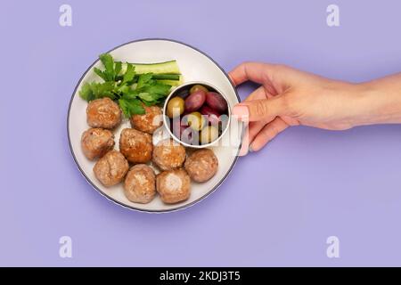 Polpette greche keftedes su sfondo a colori. Cibo tradizionale. Concetto di fotografia creativa. Vista dall'alto, spazio di copia Foto Stock