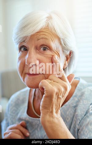 Le rughe indicano semplicemente dove sono stati i sorrisi. Ritratto di una donna anziana felice che mostra le sue rughe a casa. Foto Stock