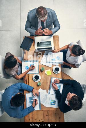 Portare le loro strategie migliori al tavolo. Scatto ad angolo alto di un gruppo di uomini d'affari che hanno una riunione in un ufficio. Foto Stock