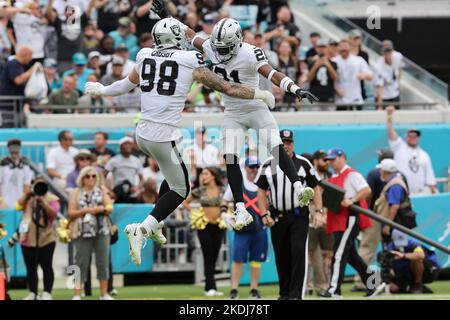 Sabato 6 novembre 2022; Jacksonville, Florida USA; Las Vegas Raiders Defensive End Maxx Crosby (98) e Cornerback Amik Robertson (21) festeggiano la sosta Foto Stock