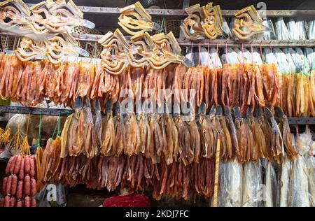 Pesce secco e carne appesi in mostra in una bancarella nel mercato di Siem Reap, Cambogia. Foto Stock