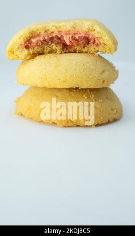 Pila di biscotti con crema di fragole closeup isolato su sfondo blu Foto Stock