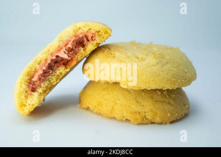 Pila di biscotti con crema di fragole closeup isolato su sfondo blu Foto Stock