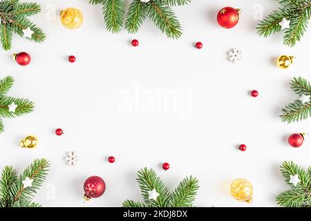 Composizione di Natale. Struttura in abete, decorazioni festive, bacche rosse su fondo bianco. Giacitura piatta. Vista dall'alto con spazio di copia. Vacanze invernali Foto Stock