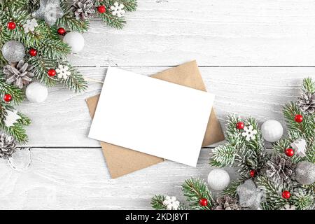 Biglietto di auguri natalizio con abete, decorazioni rosse per le feste su sfondo bianco in legno. Beffa. Giacitura piatta. Vista dall'alto Foto Stock