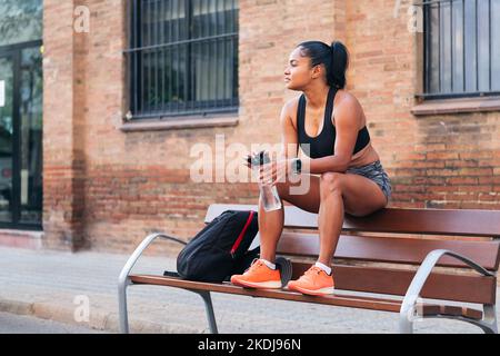 atleta femminile che riposa durante una pausa in allenamento Foto Stock