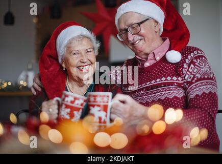 Felice coppia anziana che festeggia la vigilia di Natale insieme. Foto Stock