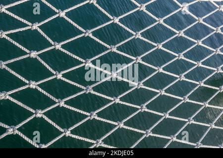 Rete di sicurezza di una nave a vela sopra il mare sfondo astratto. Foto Stock