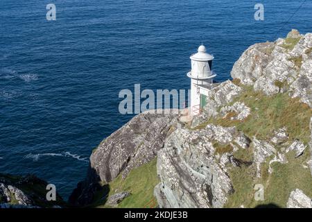 faro bianco sul bordo della roccia presso l'oceano atlantico in irland Foto Stock