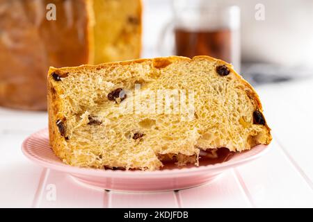 Torta di Natale panettone. Pane dolce italiano sul tavolo da cucina bianco. Foto Stock