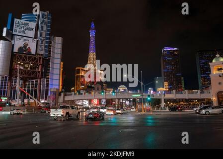 Replica della torre Eiffel illuminata vista dalla strada trafficata di Las Vegas di notte Foto Stock