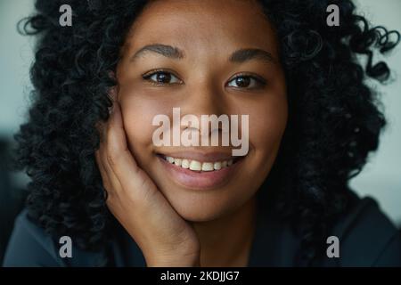 Donna affascinante mettere mano alla sua guancia e guarda la macchina fotografica Foto Stock