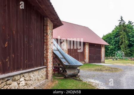 vecchia macchina agricola sullo sfondo di un bel granaio Foto Stock