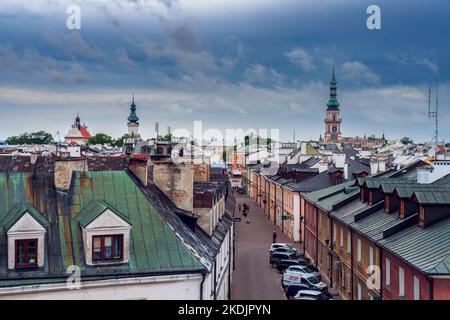 Zamość, Polonia - 10 luglio 2022: Vista della città vecchia dai bastioni. Tetti di case di inquilini. Chiesa torre sullo sfondo. Zamosc, Polonia Foto Stock