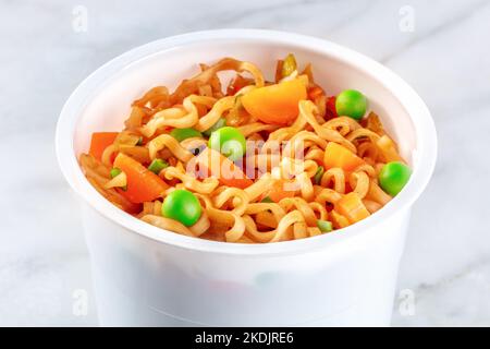 Tazza di ramen, spaghetti di soba istantanei in una tazza di plastica con verdure, un primo piano Foto Stock