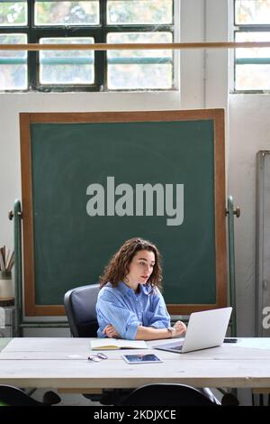Insegnante o allenatore online femminile che ha una classe remota sul computer portatile in classe. Foto Stock
