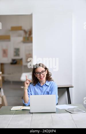 Una donna o uno studente felice che lavora su un computer portatile e che indica di avere un'idea. Foto Stock