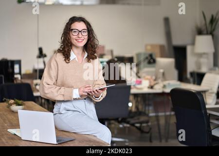Sorridente donna d'affari professionale che utilizza un tablet digitale in ufficio. Foto Stock