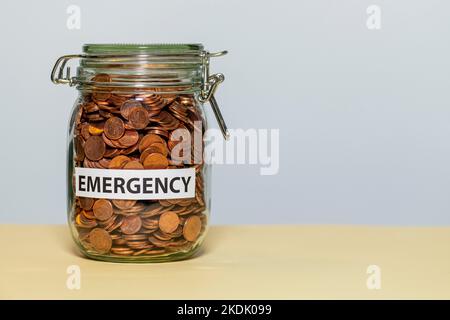 un vasetto di conservazione pieno di monete con l'etichetta di emergenza Foto Stock