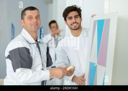 ritratto di uomini che fanno lavori di pittura con nastro adesivo Foto Stock