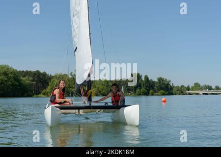 giovane donna e uomo che si preparano a navigare insieme Foto Stock