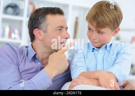 Uomo che punta il dito verso il bambino Foto Stock