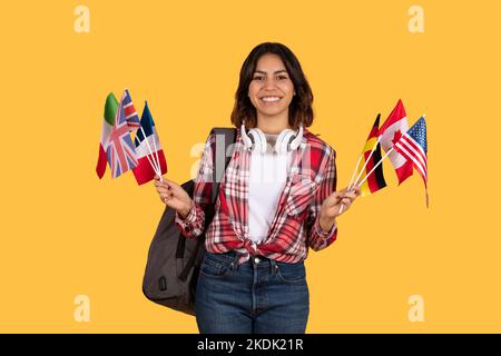 Felice studente medio orientale donna che tiene diverse bandiere Foto Stock