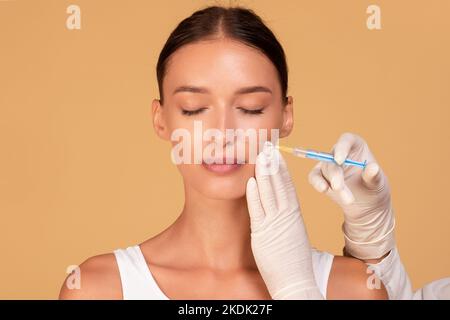 Giovane donna caucasica ottenere acido ialuronico filler per le sue pieghe nasolabiali, sbarazzandosi di rughe mimiche Foto Stock