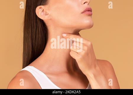 Concetto di assistenza sanitaria, freddo e persone. Primo piano di una donna malata che soffre di mal di gola, toccando il collo con la mano Foto Stock