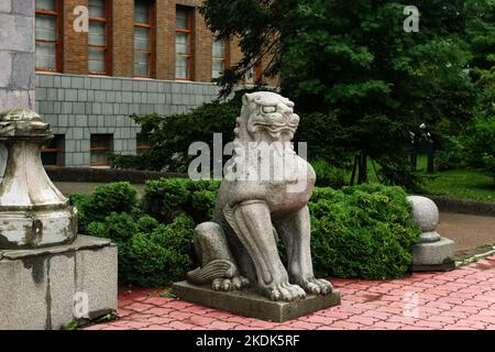 Yuzhno-Sakhalinsk, Russia - 05 agosto 2022: Statua giapponese tradizionale di un leone di pietra all'ingresso del Museo Sakhalin di Lore locale Foto Stock