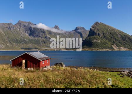 casa in legno rosso pescatore a fiordo a lofoten isola norvegia europa Foto Stock
