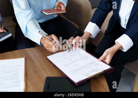 Le coppie firmano documenti importanti con gli agenti di assicurazione Foto Stock